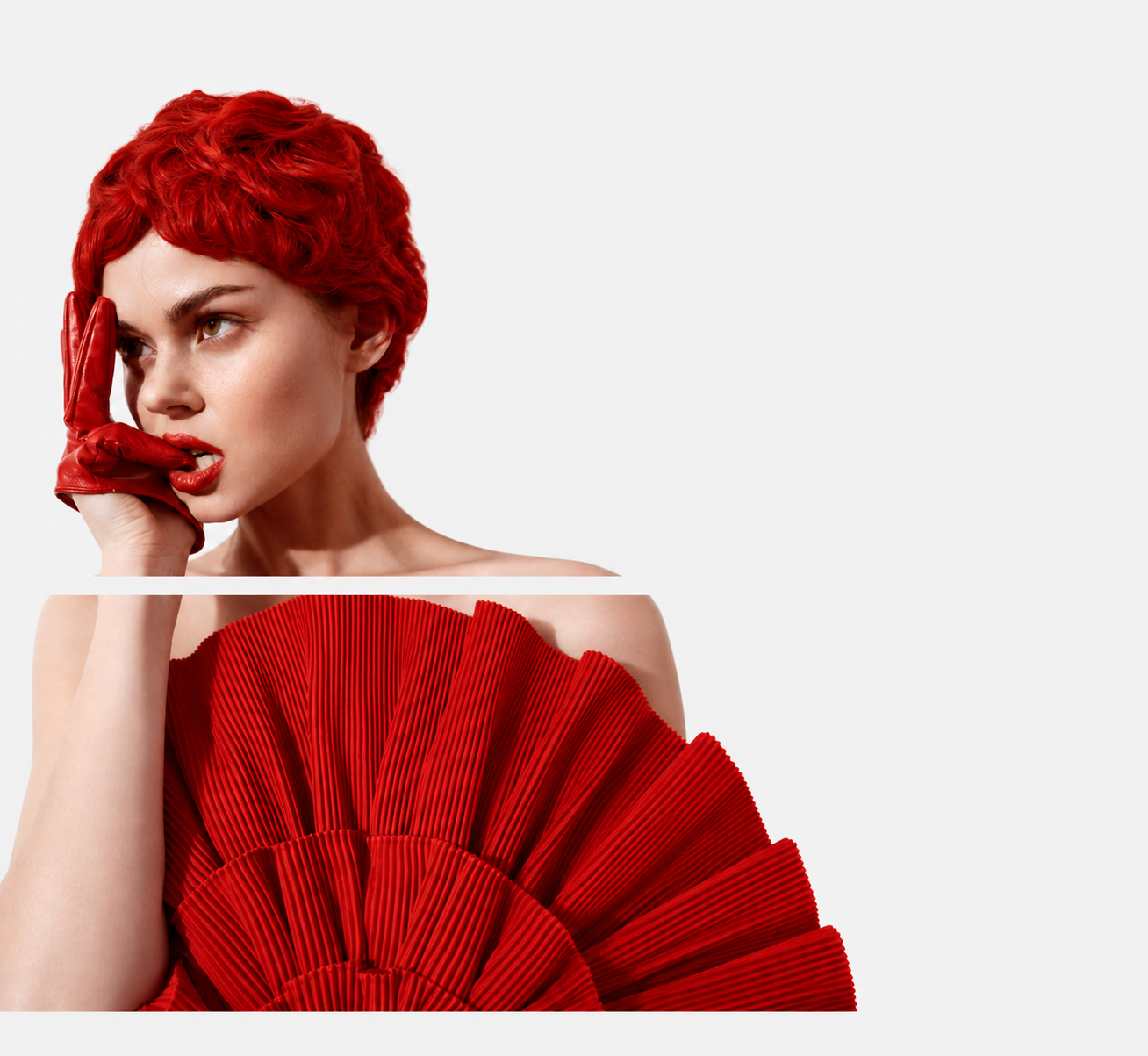 Editorial portrait with red hair, a red glove and a sculptural red fan
